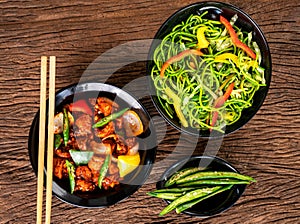 Asian food on wooden background with chop sticks