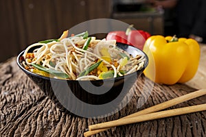 Asian food on wooden background with chop sticks