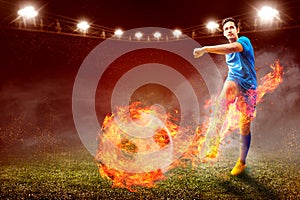 Asian football player man in blue jersey with kicking the ball with fire effect