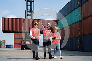 Asian foreman walking and explaining the various operations in the container depot terminal to worker