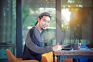 Asian freelance man working on computer laptop toothy smiling fa