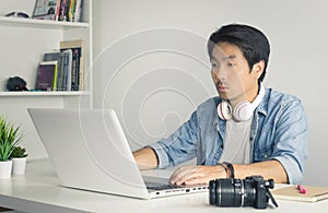 Asian Freelance Videographer Work from Home Editing Multimedia File by Laptop in Home Office in Vintage Tone