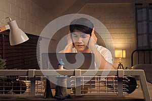 Asian freelancer feeling overwhelmed and stressed working overtime during nightshift