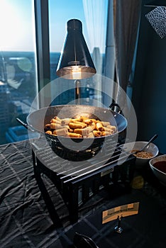 Asian fried eggrolls dish being cooked on the stove under a light near the window photo
