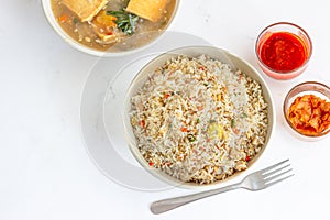 Asian fried Rice in a Bowl with Condiments Directly Above Photo