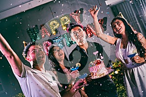 Asian friends having fun in birthday party at night club with birthday cake. Event and anniversary concept. People lifestyles and
