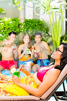 Asian friends partying at pool party in resort