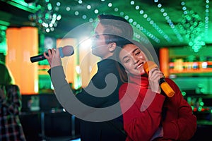 Asian friends singing songs karaoke on night club stage