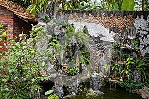 Asian garden decoration. Traditional home garden with fountain, rocks, towers, trees and walls