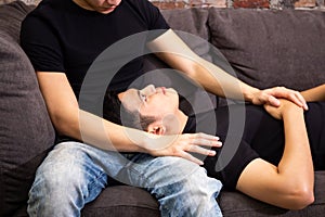 Asian gay couple looking at each other together on sofa at vintage home. Portrait of happy gay men - Homosexual love concept.