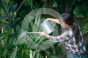 Asian geautiful young woman gardening outside in summer nature