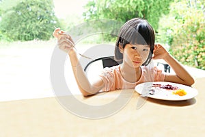 Asian girl 6s eat breakfast meal plate sit in table