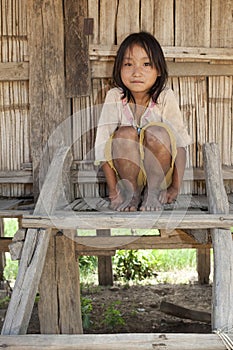 Asian girl Akha before timber house, Laos