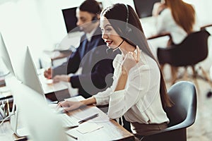 The Asian girl answers questions from clients in the call center.