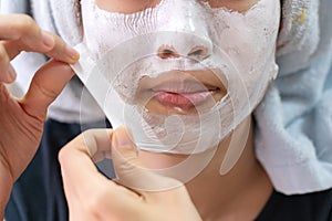 Asian girl applying facial cream mask