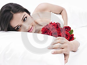 Asian girl in bed with red roses