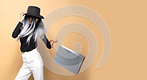 Asian Girl with black hat white pants throw silver bag