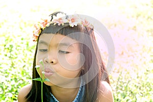 Asian girl blow the flowers on nature blur background.