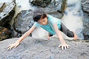 Asian girl children doing rock climbing with free hand