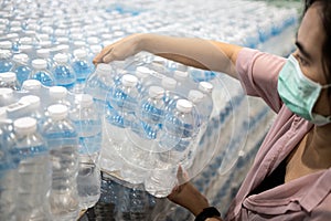 Asian girl choosing pure fresh water or buying and hoarding during the COVID-19 Coronavirus pandemic,selecting clean water,