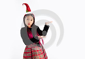 Asian girl in christmas theme costume wear santa hat headband hand presenting and point copy