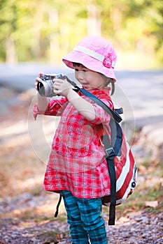 Asian girl with digital camera in beautiful outdoor.