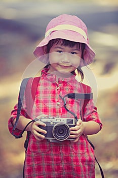 Asian girl with digital camera in beautiful outdoor. Vintage pic