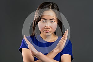 Asian girl disapproving with no crossing hands sign make negation gesture. Denying, Rejecting, Disagree, Portrait of