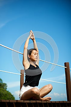 Asian girl doing Yoga at the pier