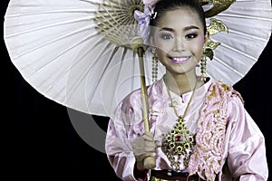 An Asian girl dressed in traditional costumes and holding a paper umbrella, a famous handicraft in northern Thailand