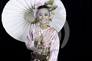 An Asian girl dressed in traditional costumes and holding a paper umbrella, a famous handicraft in northern Thailand