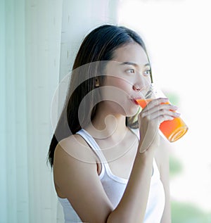Asian girl drinking orange juice