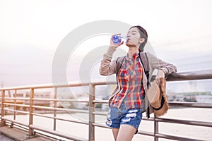 Asian girl Drinking water Stay tired of thirst tourist backpack relax time on holiday
