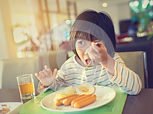 Asian girl eating breakfast with pajamas.