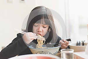 Asian girl eating chashu ramen in japanese restaurant