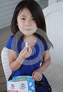 Asian girl eating popcorn