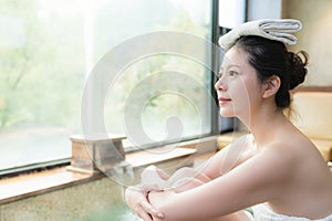 Asian girl enjoy the view sitting on poolside