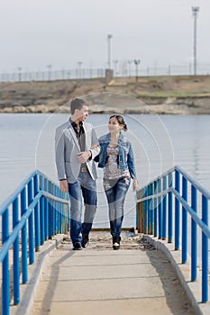 Asian girl and european guy walking along pier