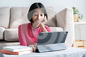 Asian girl expression excited on face while watching  tablet, Asia child emotion surprise at computer in the living room at home