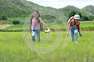 Asian girl and friend running and enjoy in the field meadows outdoors,