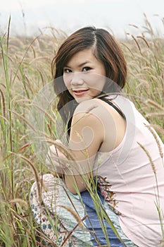 Asian girl among grass