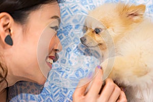 Asian girl and her cute dog staring into each other's eyes