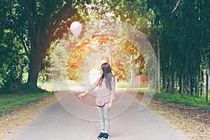 Asian girl holding a balloon in the park