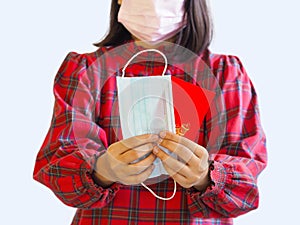 Asian girl holding face mask and  red evelope angpao for gift on Chinese new year holiday