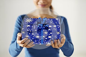 Asian girl holding gift box to the camera