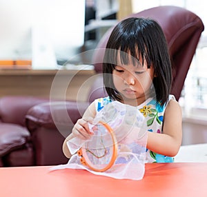 Asian girl home schooling sewing