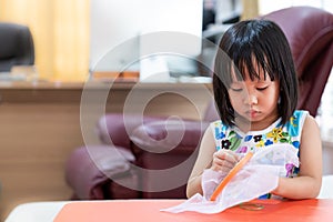 Asian girl home schooling sewing