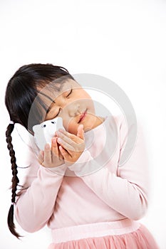 An Asian girl is hugging a piggy bank and dreaming of the future in a white background