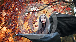 Asian girl in kimono on background of red maple