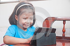 Asian Girl learning online course or playing game online at home